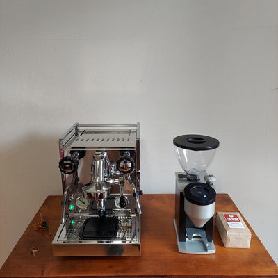 top view of rocket appartamento with custom drain tray and diverter spout, coffee grinder and beans on wooden table